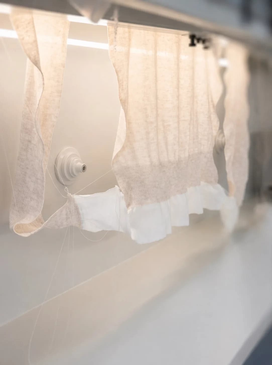 White knitted panels hanging on a production fixture