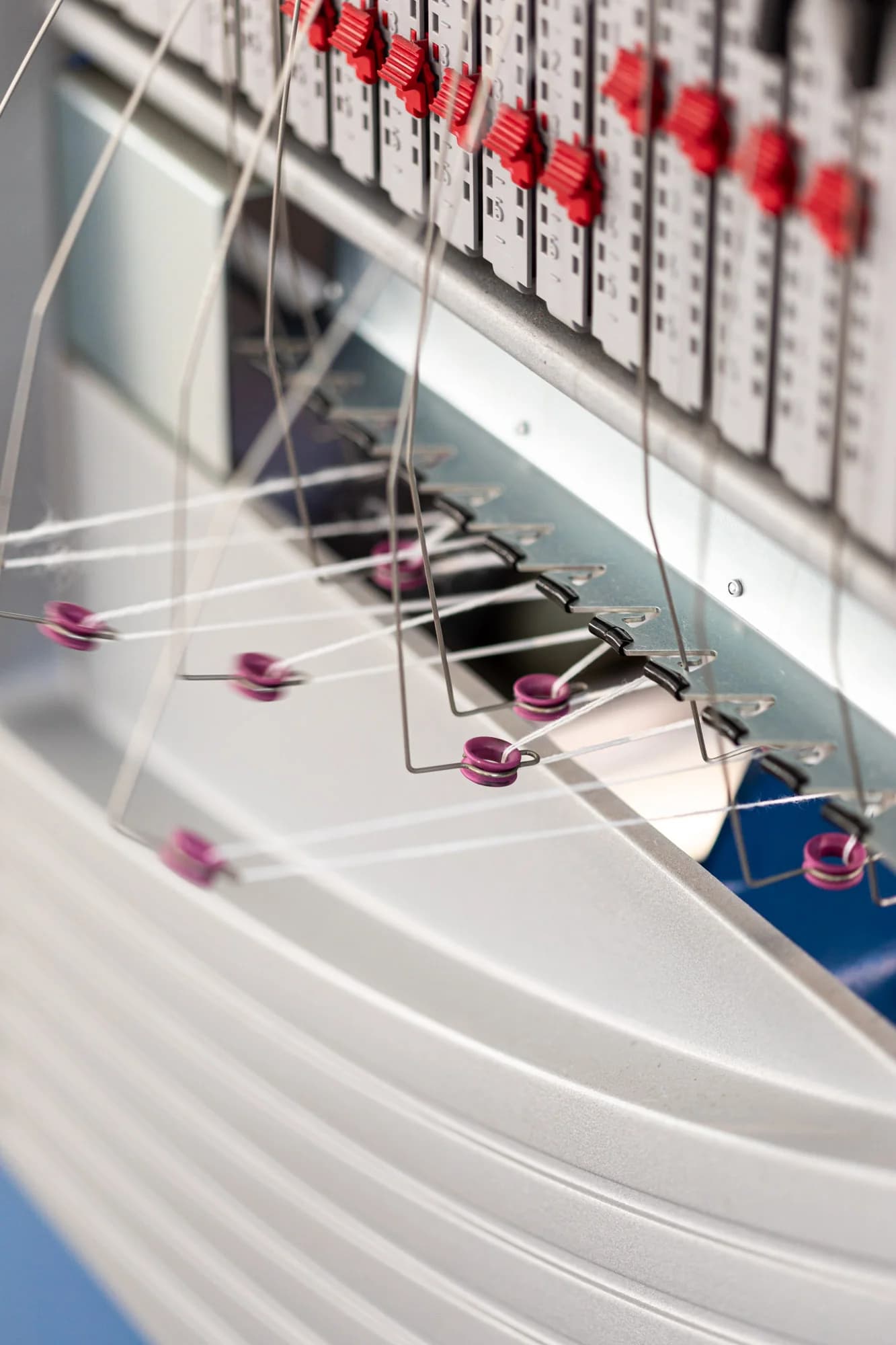 Yarn guides and needle bed details on a flat knitting machine